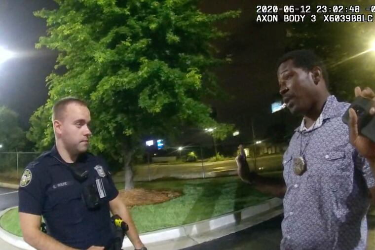 Rayshard Brooks, right, speaks with Officer Garrett Rolfe, left, in the parking lot of a Wendy's restaurant in Atlanta on June 12, 2020.