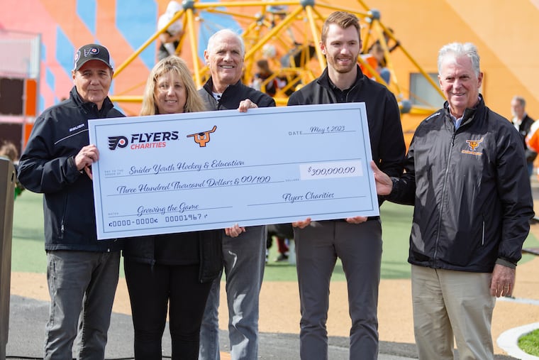 Scott Tharp, from left, Cindy Stutman, Dan Hilferty, Sean Couturier, and Bill Whitmore present a check for a Learn to Play program at the ribbon cutting ceremony for the outdoor street hockey rink at the Joseph Scanlon Recreation Center on Monday, May 1, 2023.