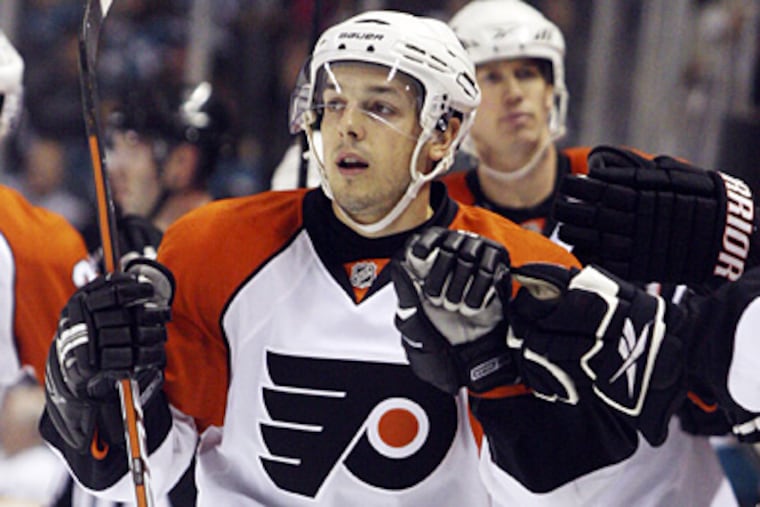 Danny Briere is greeted by teammates at the bench after scoring a goal in the Flyers' 6-3 loss to the San Jose Sharks. (AP Photo/George Nikitin)