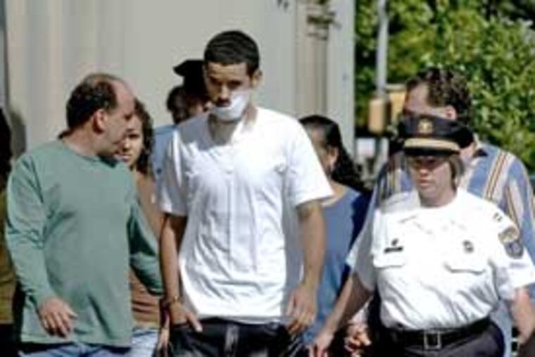 Philadelphia policeman Richard DeCoatsworth, who was shot in the face last week, being escorted by his father, Mark (left), and other relatives and officers.