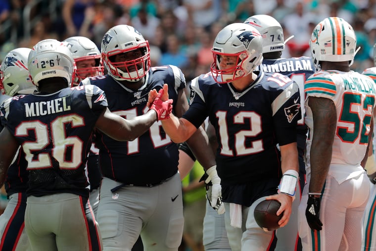 Patriots running back Sony Michel (left) congratulates quarterback Tom Brady during their 43-0 win in Miami last Sunday. Up next for the Dolphins, who've been outscored by 102-10, is a trip to Dallas. Miami is a 21.5-point underdog.