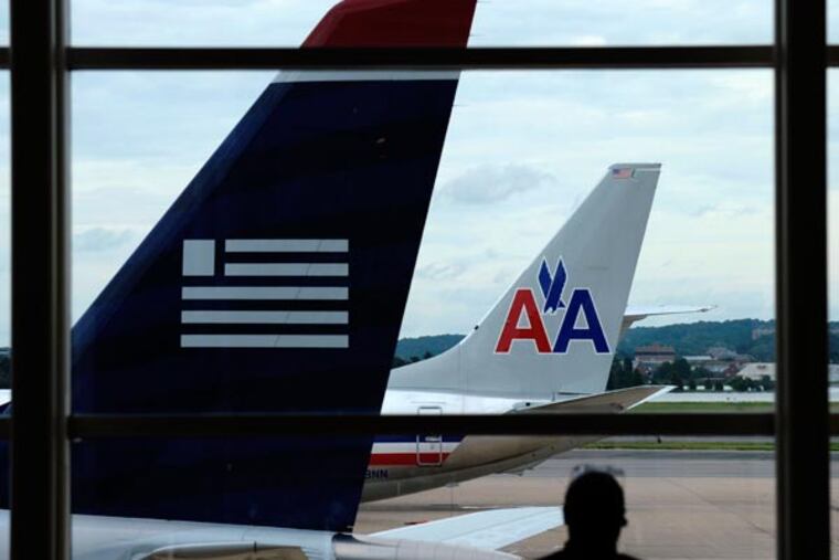 In this Tuesday, Aug. 13, 2013, photo, an American Airlines plane and a US Airways plane are parked at Washington's Ronald Reagan National Airport in Washington. The government is putting its foot down on rising airfares and fees by blocking the merger of American and US Airways _ but for fliers, it's already too late. (AP Photo/Susan Walsh, File)