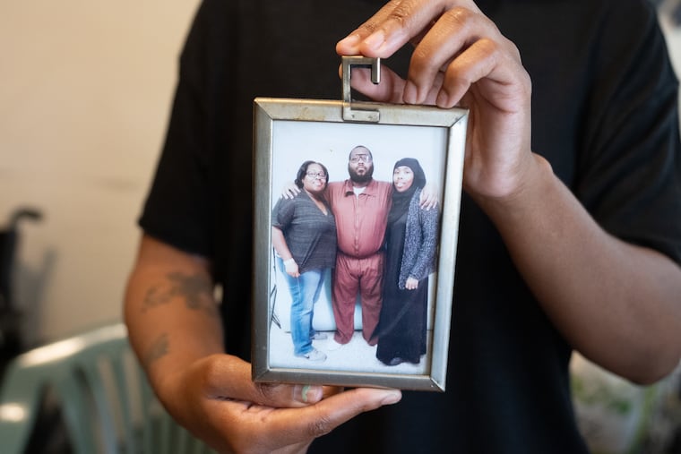 Tamira Musier holds up a photo of a visit with her brother in prison.