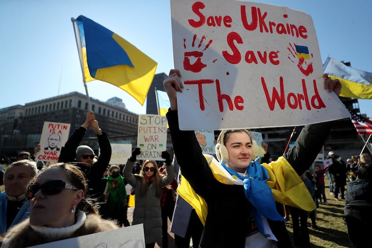 Nadia Kozij (right), of Philadelphia,holds a sign sign during the rally.