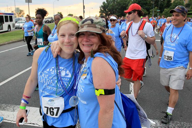 As walkers step off , a couple of participants pause before continuing the 17-mile trek, which was taking them past Boathouse Row and through University City, among other places. CHARLES FOX / Staff Photographer