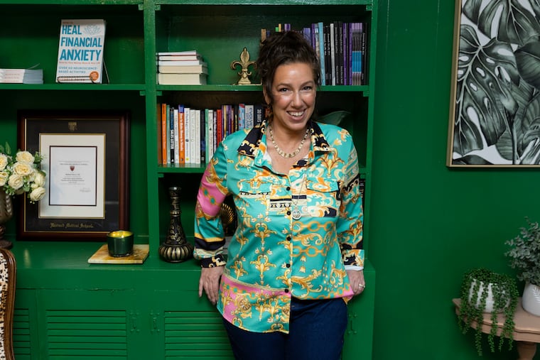 Michele Paiva, a licensed therapist and certified financial educator, poses for a portrait at her home office in Downingtown, Pa., on Wednesday, Dec. 13, 2023. She counsels clients on financial stressors, hosts a podcast about money and mental health, and has written several books.
