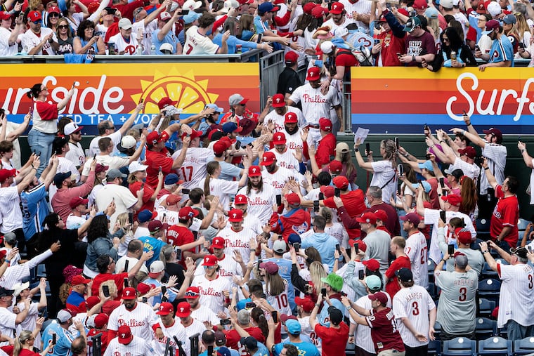 Phillies players walk down to the field during player introductions before the game. Despite ominous forecasts, it turned out to be a great day for the home team.