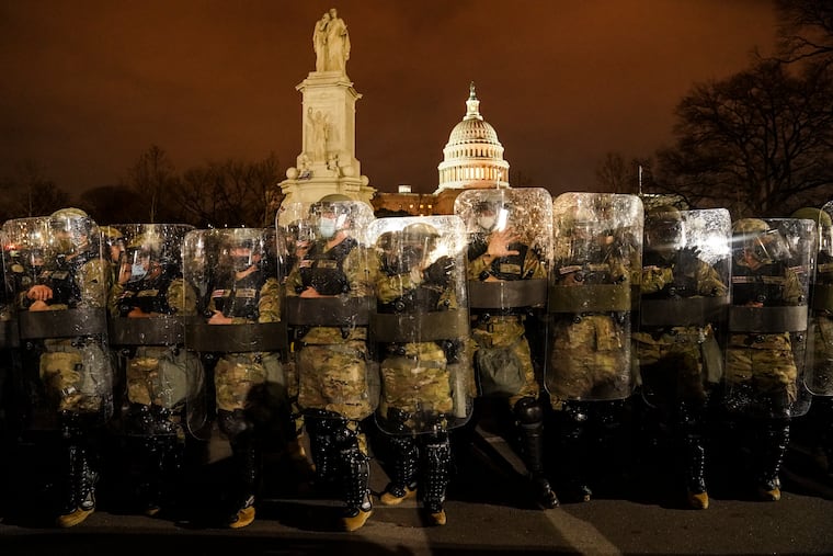 District of Columbia National Guard stand outside the Capitol after a day of rioting.