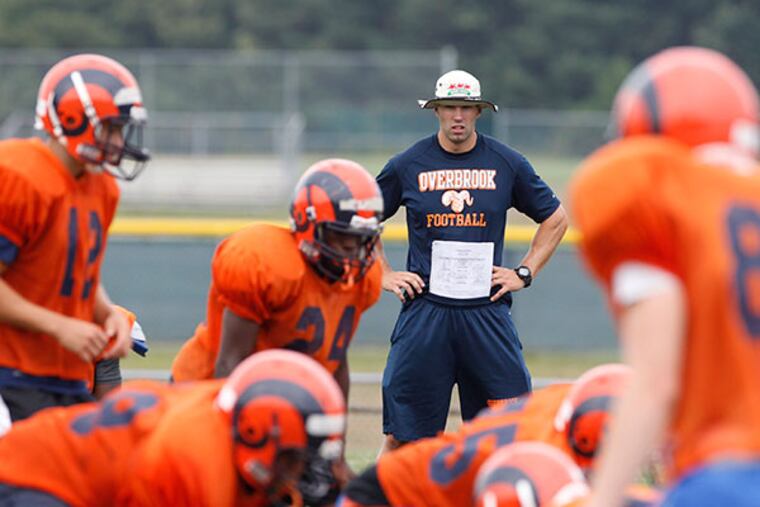 Frank Wilczynski, center, takes over as head coach at his alma mater, Overbrook High School in Pine Hill, NJ. He watches his team run through plays at practice on Aug. 31, 2015.