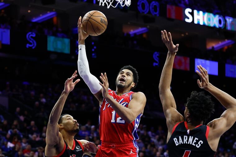 Sixers forward Tobias Harris drives to the basket against Toronto Raptors forward Otto Porter Jr., (left) and forward Scottie Barnes in the second quarter.