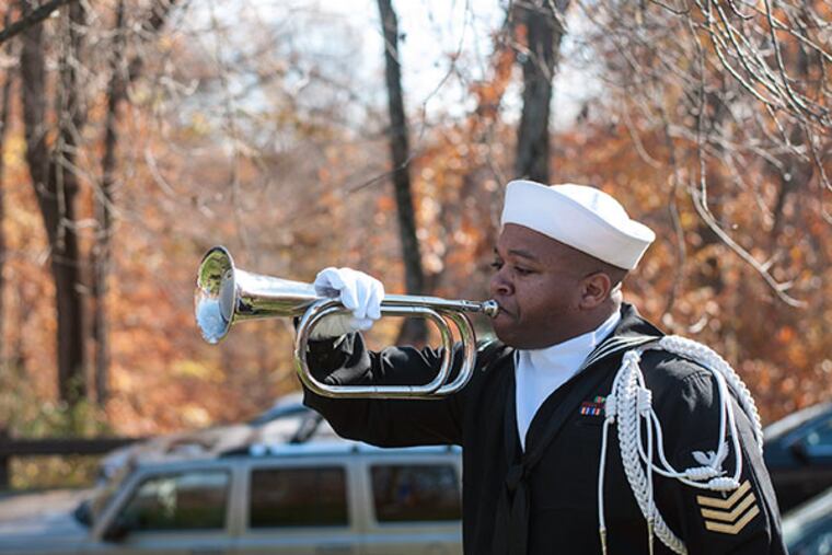 Petty Officer First Class Jermaine Smith of Philadelphia sounds Taps after the flags were interned. (PATRICK MCPEAK/STAFF PHOTOGRAPHER)