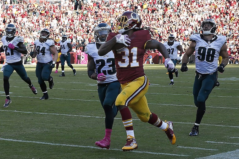 Redskins' Matt Jones picks up a 1st down as Eagles' defenders give chase late in the 4th quarter. Philadelphia Eagles lose 27-20 to the Washington Redskins at FedEx Field in Landover, MD on October 16, 2016. DAVID MAIALETTI / Staff Photographer