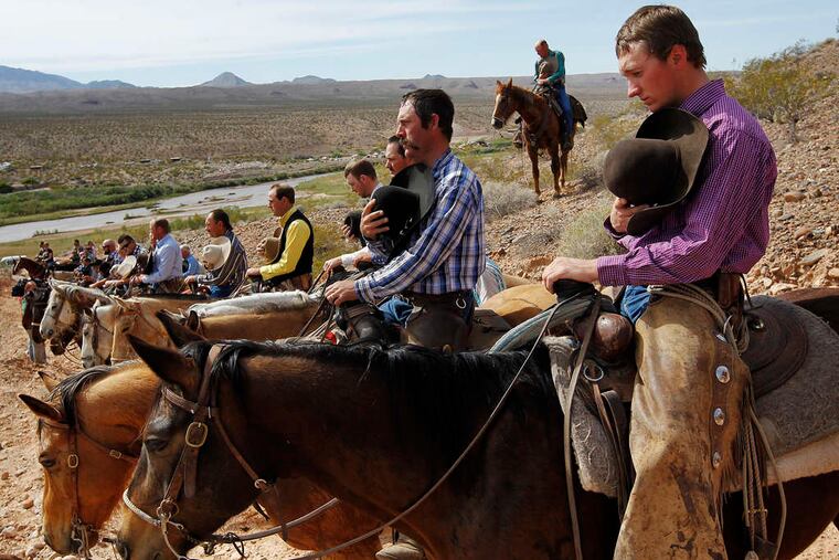 Government protesters pause for the national anthem during a standoff with officials of the Bureau of Land Management.