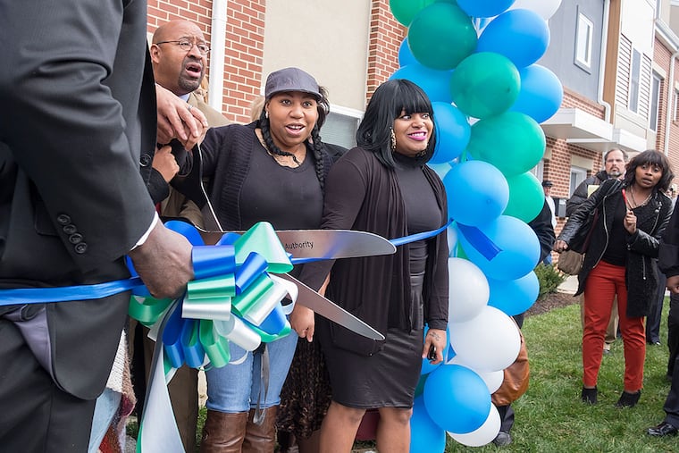 New Queen Lane residents Shaqueia Johnson (center) and Jenise Davis join Mayor Nutter and Philadelphia Housing Authority officials for a ribbon-cutting ceremony.
