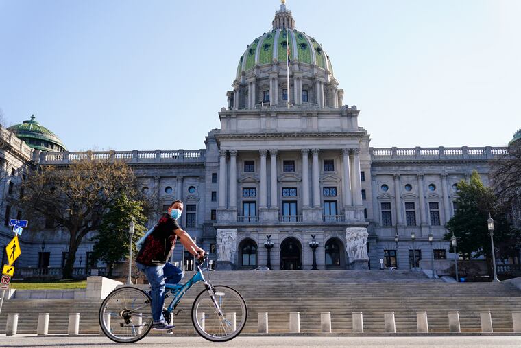 A cyclist rides past the Pennsylvania Capitol in Harrisburg.