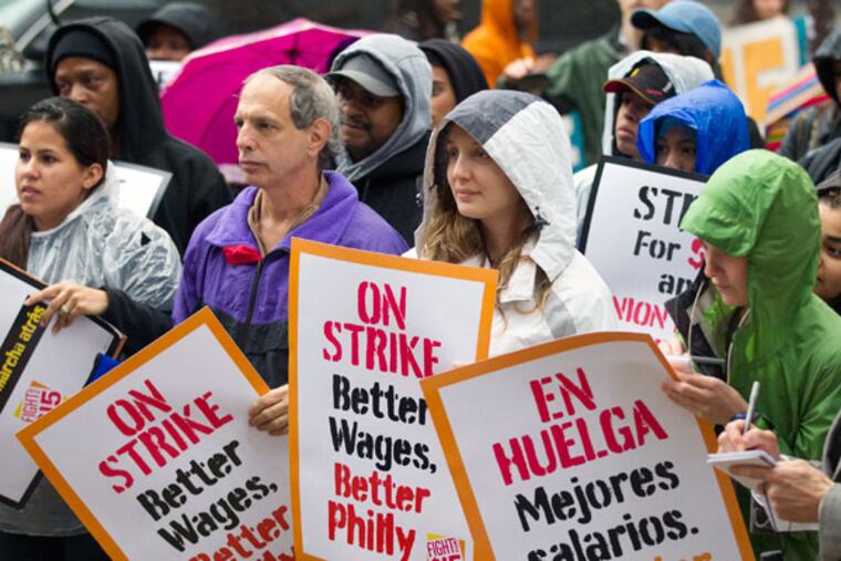 At City Hall, signs were in both English and Spanish. Tuesday’s rain left participants soggy. The push for a higher minimum wage has more support among Democrats than Republicans.
