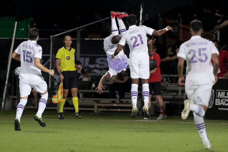Orlando City's Benji Michel, center, celebrates with teammates after his goal clinched the win.