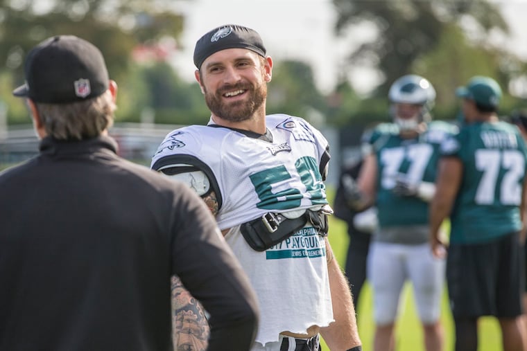 Eagle defensive end Chris Long, #56, right, shares a moment with a coach before practice. MICHAEL BRYANT / File Photograph