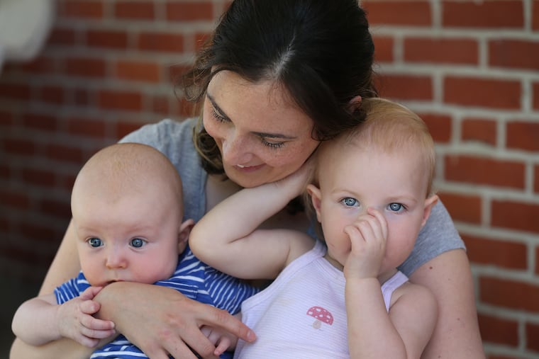 Taryn McNabb holds her 4-month-old son John, left, and 17-month-old daughter Madeleine, right, in Bryn Mawr, PA on May 24, 2018.