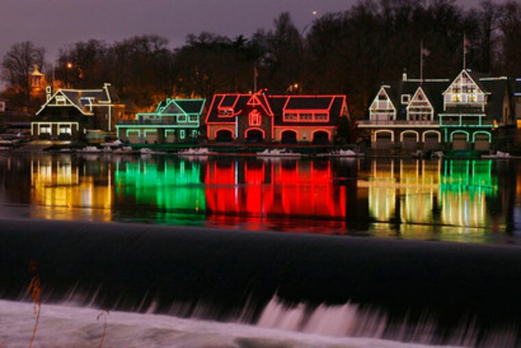 LIGHTS REFLECTED in the Schuylkill along Boathouse Row provide a festive yuletide scene. The best place to view the scene is from across the river on Martin Luther King Jr. Drive.