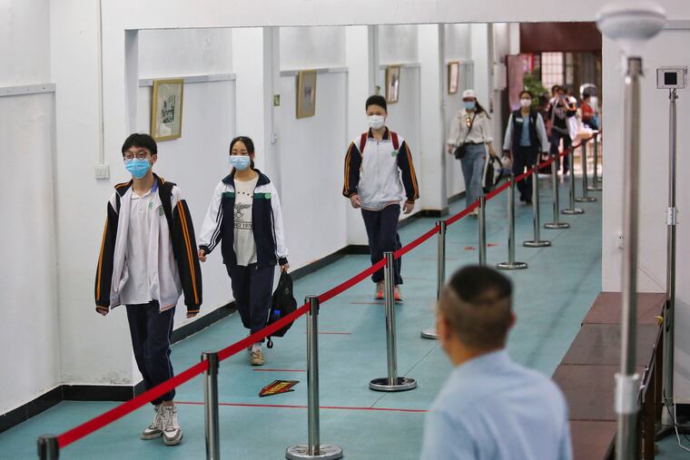 Students wearing masks to help curb the spread of the coronavirus walked in social distancing as they arrived to a high school in Wuhan last Wednesday.