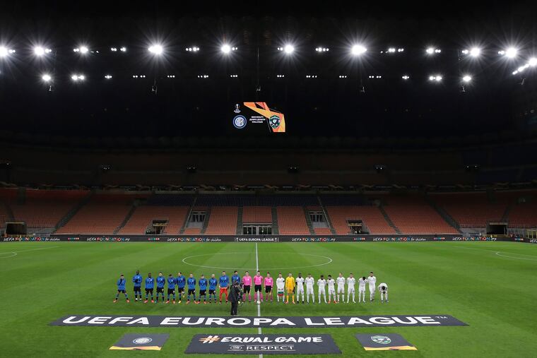 Inter Milan, left, and Ludogorets line-up inside the empty San Siro stadium in Milan, Italy ahead of their Europa League round of 32 second leg soccer match on Feb. 27. The teams played in an empty stadium as a precaution because of the virus outbreak in Italy.