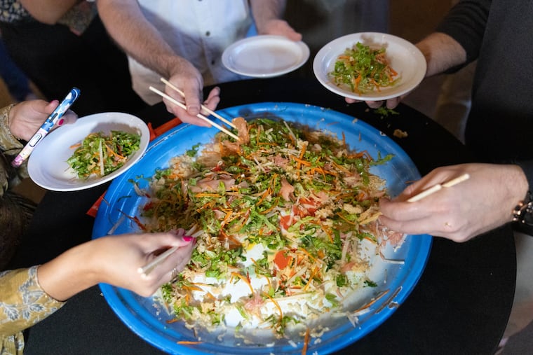 Digging into Kampar's yee sang, a prosperity salad eaten at Chinese New Year.