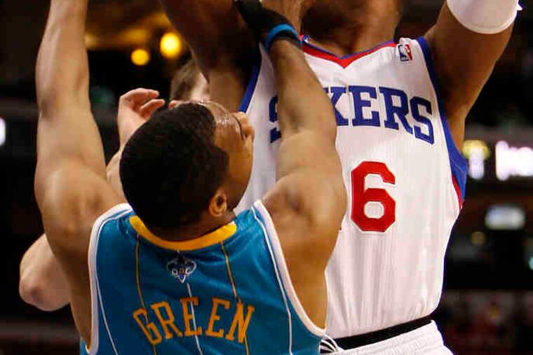 Marreese Speights is fouled by Hornets' Willie Green, a former Sixer, during yesterday's win.