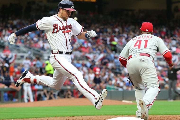 Braves’ outfielder Lane Adams beats out the throw to Phillies’ first baseman Carlos Santana (right) for a single during the seventh inning of the Phillies’ opening-day loss.