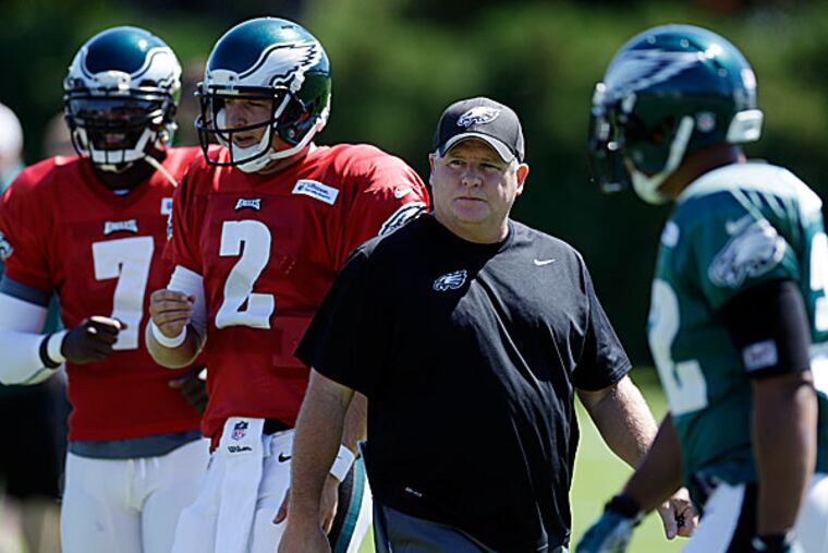 Eagles head coach Chip Kelly directs practice as quarterbacks Michael Vick and Matt Barkley run a drill. (Matt Rourke/AP)