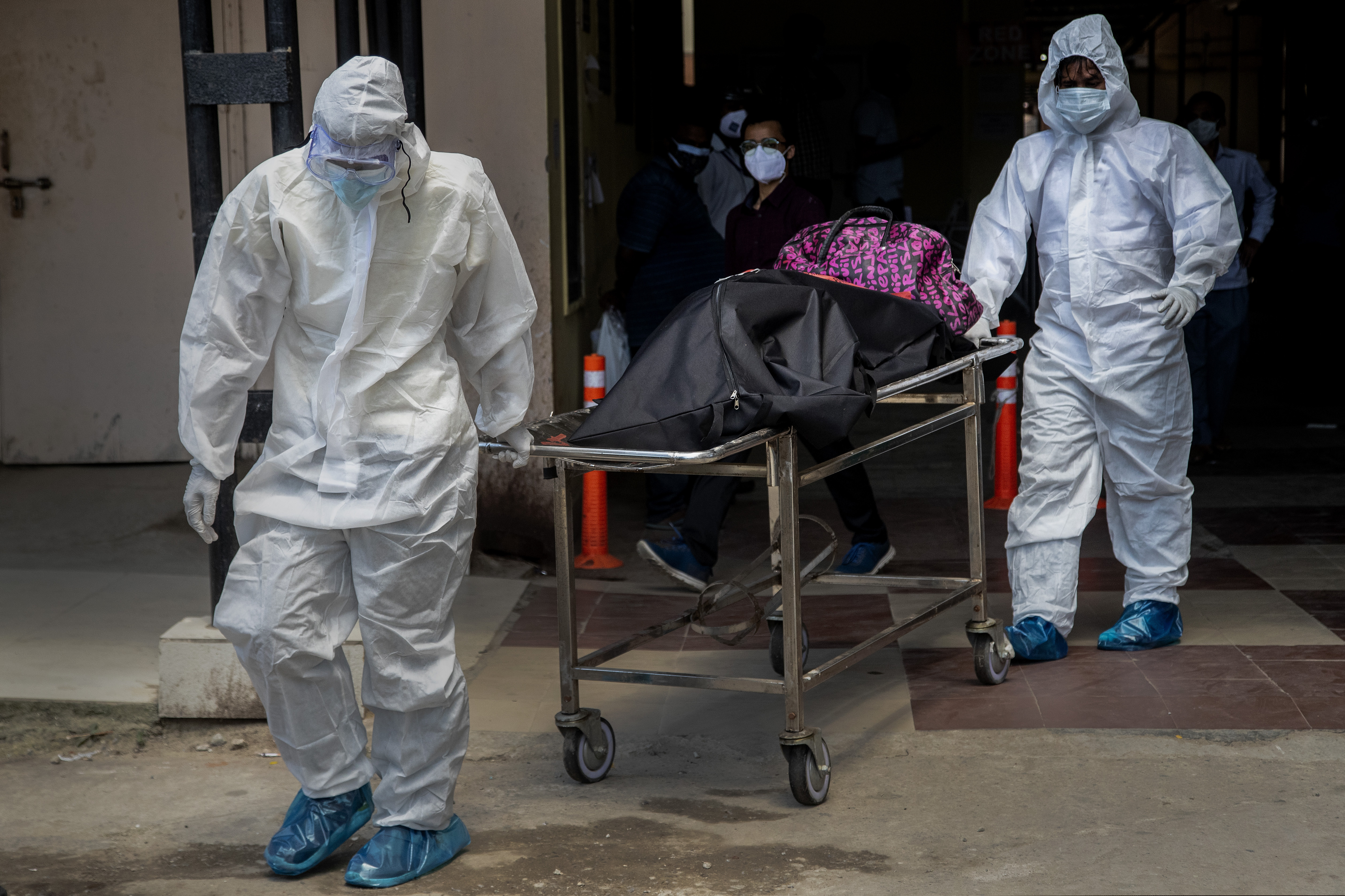 Health workers in protective suits shift the body of a COVID-19 victim at a government hospital May 24 in Gauhati, India. The nation has lost more than 300,000 people to the coronavirus, illustrating that the pandemic is far from over.