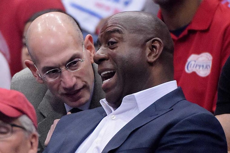 NBA Commissioner Adam Silver, left, talks with Magic Johnson as they watch the Los Angeles Clippers play the Oklahoma City Thunder in the first half of Game 4 of the Western Conference semifinal NBA basketball playoff series, Sunday, May 11, 2014, in Los Angeles. (AP Photo/Mark J. Terrill)
