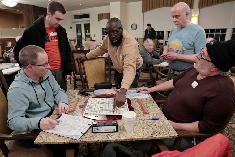 (L-R) Brendan McClanahan of Havertown, Evan Chester of Southampton, Clay Herron of Dover, Del., Edwin Roth of Conshohocken and Joe Geibler of Folsom have a spirited exchange during a Scrabble group meetup at Riddle Village in Media on Thursday, Feb. 12, 2026.
