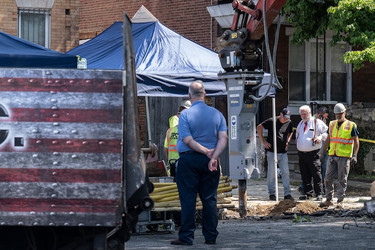 Workers and police investigators dig and inspect a hole while removing pipes and debris at the entrance to the home of Eugene Albert Horsch on West Chew Avenue.