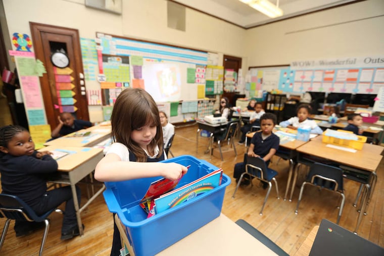 Juliana Tammela picks a donated book in Kim Robertson's first grade class at Crossen Elementary School. The organizing committee from this summer's Democratic National Convention is donating nearly $1 million to the Philadelphia School District's Right Books campaign, which places classroom libraries at elementary schools across the city, Friday December 16, 2016 ( DAVID SWANSON / Staff Photographer )