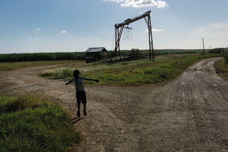 A youth plays near the machine where the sugar cane is weighed in the Lima batey, or neighborhood, in La Romana, where Central Romana Corporation, Ltd. operates its sugar operations in Dominican Republic, Nov. 17, 2021. The U.S. government announced Nov. 23, 2022 that it will detain all imports of sugar and related products made in the Dominican Republic by Central Romana Corporation, Ltd. amid allegations that it uses forced labor.