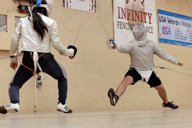 Fencing coach Andy Choi (left) battles Michael Liguori during the intermediate/advanced fencing class at Infinity Fencing Alliance in Woolwich, Gloucester County.