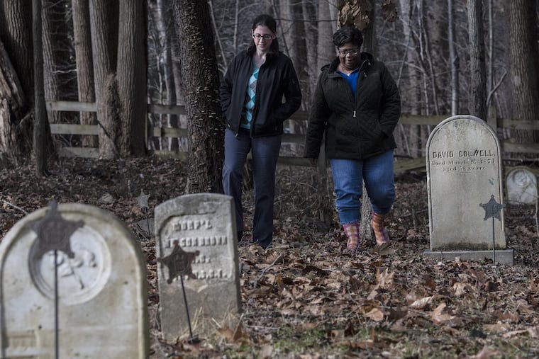 Crystal Crampton, right, and Abbie Kessler, preservation director at the Land Conservancy of Southern Chester County, walk through the Historic Bucktoe Cemetery in Kennett, Pa. Both women are part of a team working to preserve the African American cemetery that dates back to the early 1800s.