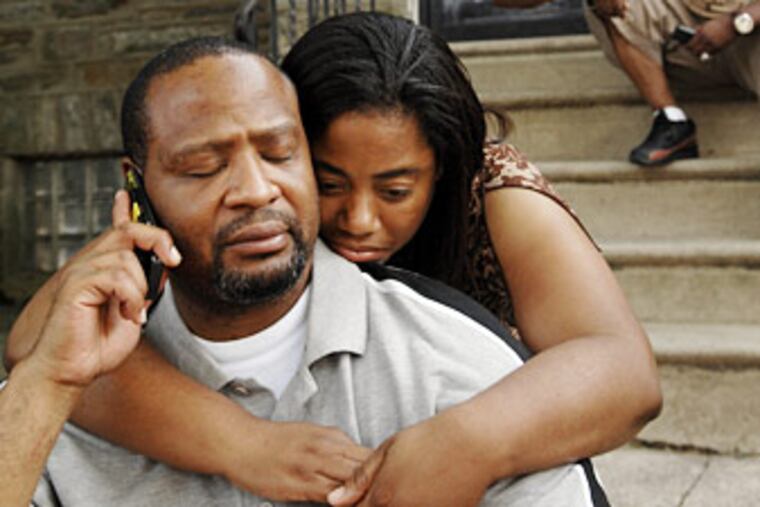 Eric Farrow (left) talks on phone yesterday as Cynthia Ragin comforts him. (ALYSSA CWANGER / Staff photographer)