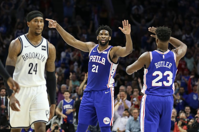 Sixers' Joel Embiid celebrates with Jimmy Butler in front of Nets' Rondae Hollis-Jefferson during the 2nd quarter of Game 5 of the first round of the NBA playoffs at the Wells Fargo Center in Philadelphia, Tuesday, April 23, 2019.