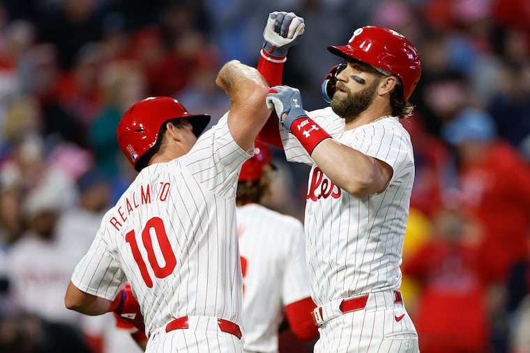 Phillies catcher J.T. Realmuto greets Bryce Harper after his three-run homer in the third inning against the Giants.