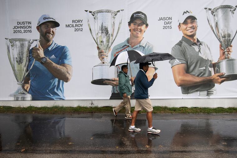Volunteers shield from the rain with umbrellas during a rainy day at the Aronimink Golf Club in Newtown Square, Pa., Sunday, Sept. 9, 2018. The BMW Championship final round is delayed due to weather.