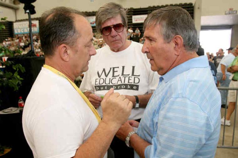 Frank Rizzo (right), son of the former mayor , huddles with bidders Gene Taylor (left) and George Poulos as they talk about terms. The Cadillac went to Poulos, a classic car collector.