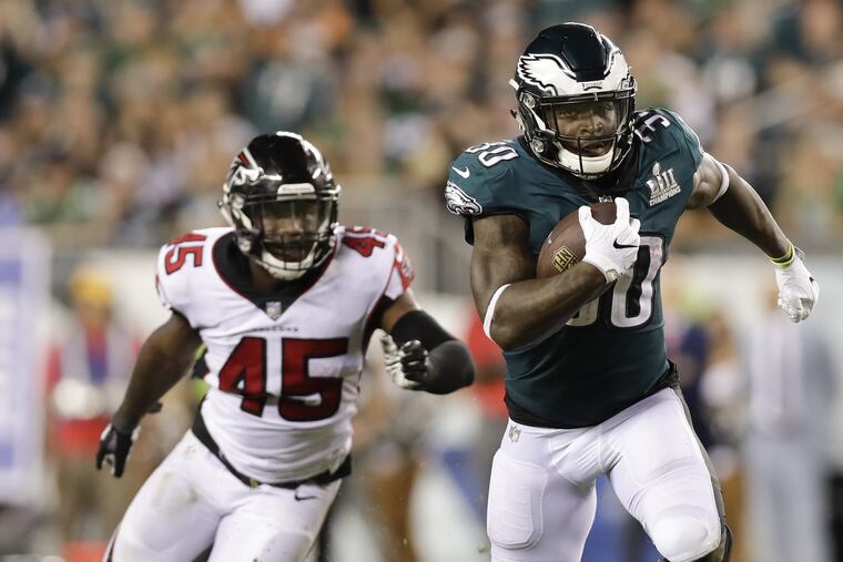 Corey Clement runs past Falcons linebacker Deion Jones during the fourth quarter on Thursday.