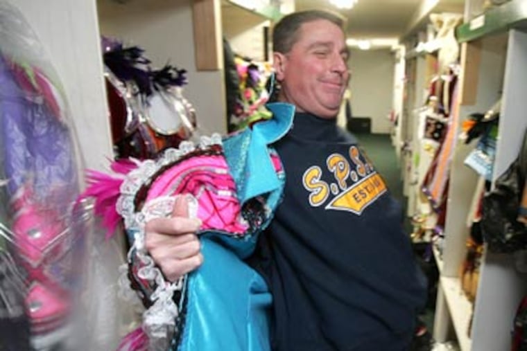 South Philly Mummer Harry Dougherty, 51, shows how hard it is to disrobe from a costume if nature calls on Broad Street. (David Swanson / Staff Photographer)