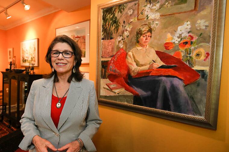 Janice Wilson Stridick at her Merchantville home on Mother's Day standing next to a painting of her by her mother on May 10, 2015. ( Steven M. Falk / Staff Photographer )