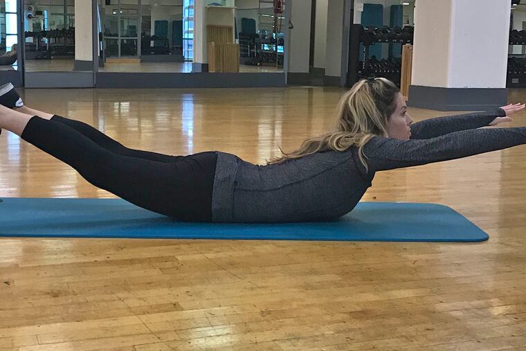 Ashley demonstrates a superman exercise.