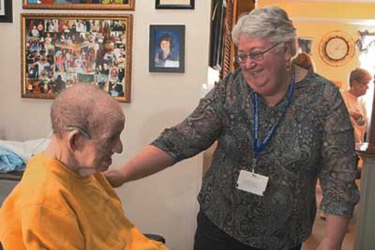 When the prognosis is grim, volunteers like Marcy Oleksiuk offer their time to the families of the terminally-ill. Oleksiuk is a volunteer with Holy Redeemer Hospital's hospice program. Here, Marcy Oleksiuk spends time with hospice patient Leslie Kincade and his family at their Warminster home. ( ED HILLE / Staff Photographer )