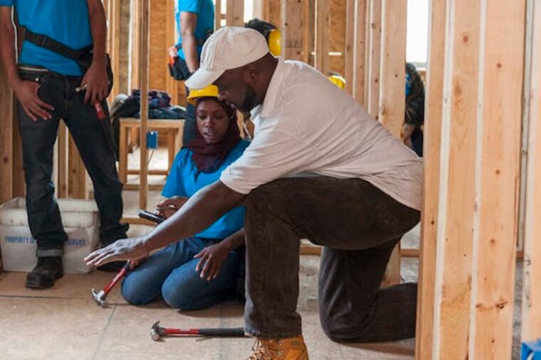 "I deserve more than the street," says Siani Clemonts, getting advice on renovations from instructor George Jenkins as fellow YouthBuild students Sean Iyles (left) and Immanuel John watch. (MATTHEW RHEIN/For The Inquirer)