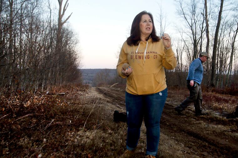 Michele Talmadge and her husband, Jason, look for signs of Bigfoot in a clearing for power lines on Bald Mountain in Bear Creek Township on April 6.
